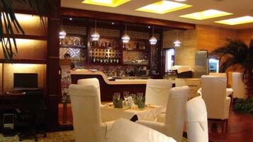 A bar area with a counter, bar stools, and a seating area with tables and chairs.