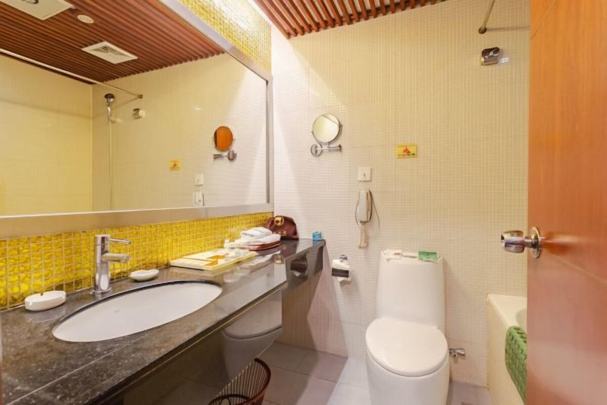 Un baño con lavamanos, espejo, inodoro y ducha.