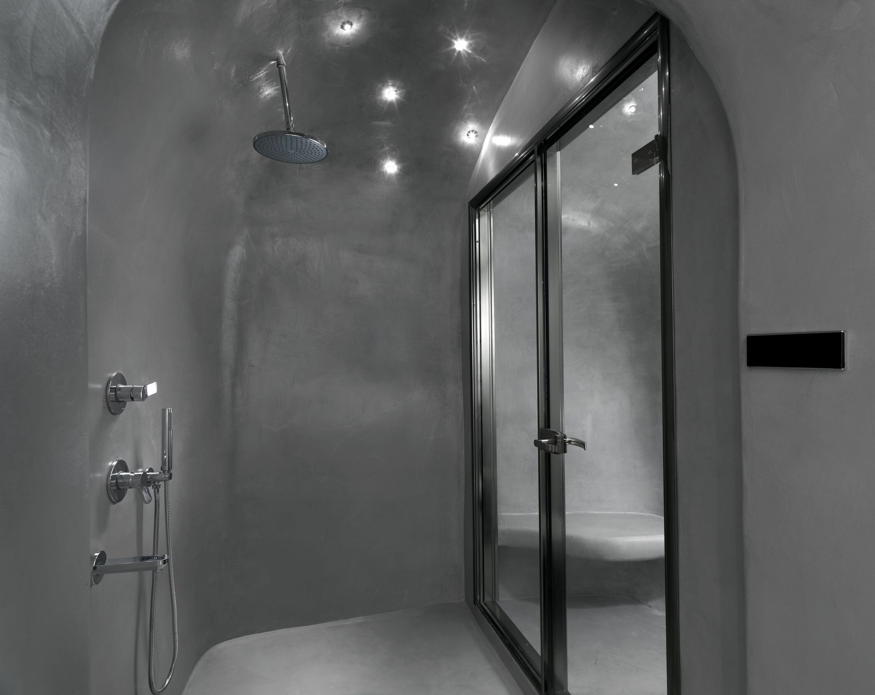 A modern shower with a handheld showerhead and a handheld shower attachment.