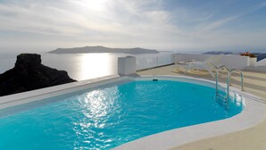 Una piscina con vistas al mar y un promontorio rocoso.