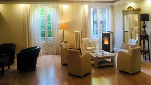 Un salón acogedor con chimenea, asientos cómodos y ventanas amplias.