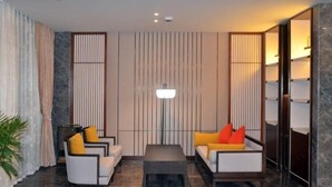A modern living room with a sofa set, a coffee table, and a floor lamp. - Tieshan Hotel (Wuhu)