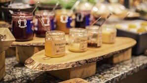 Een houten serveerplank met potten honing met de tekst 'Wild Bee Honey'.
