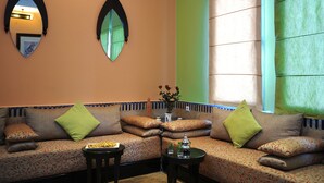 A cozy seating area with a sofa, two side tables, and decorative pillows. - ibis Marrakech Palmeraie Hotel (Marrakech)