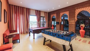 A room with a foosball table, a pool table, and a red sofa. - ibis Marrakech Palmeraie Hotel (Marrakech)
