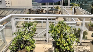 A rooftop terrace with outdoor seating, potted plants, and a view of surrounding buildings. - Hotel OK (Rio de Janeiro)