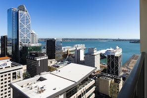 Paisagem urbana com edifícios modernos, uma orla marítima e céu claro.