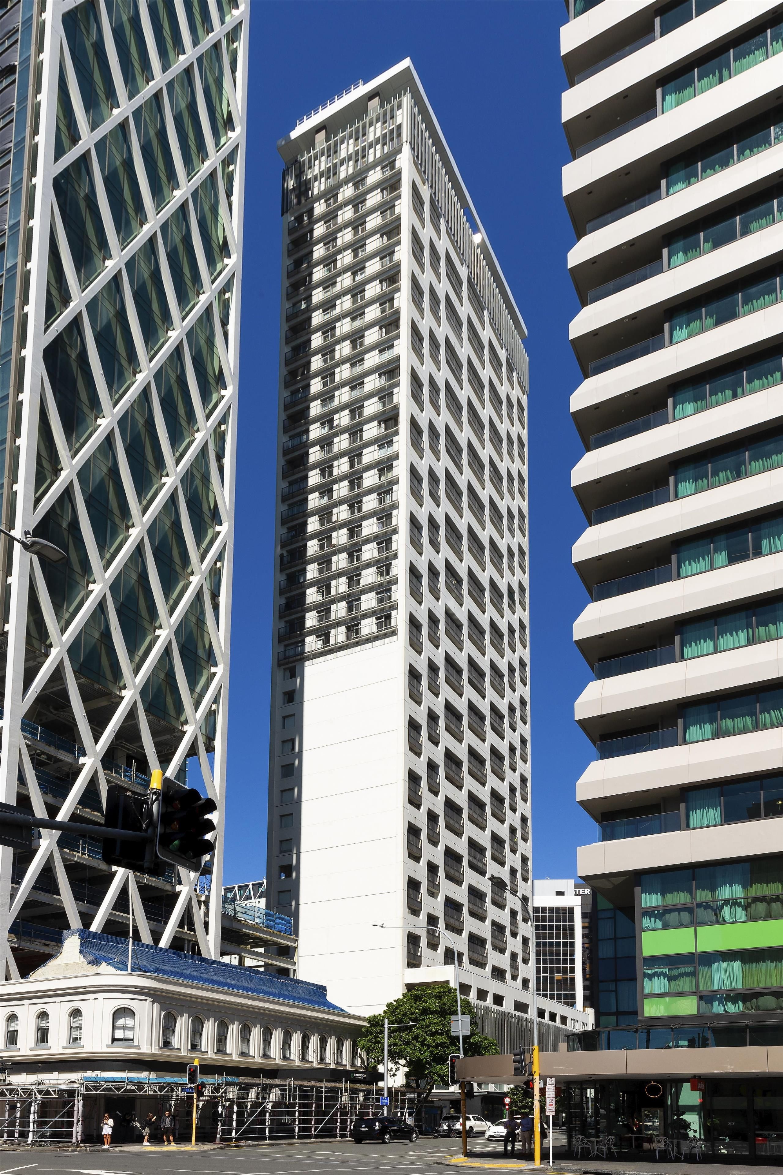 A modern high-rise building with a grid-like facade and multiple balconies.