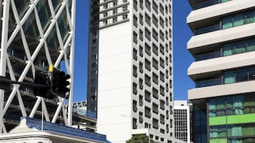 A modern high-rise building with a grid-like facade and multiple balconies.