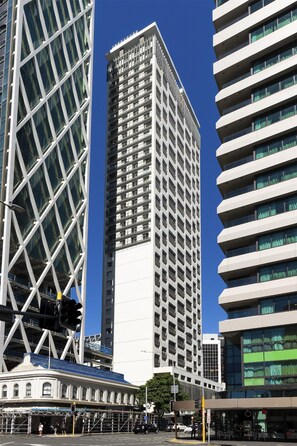 A modern high-rise building with a grid-like facade and multiple balconies.