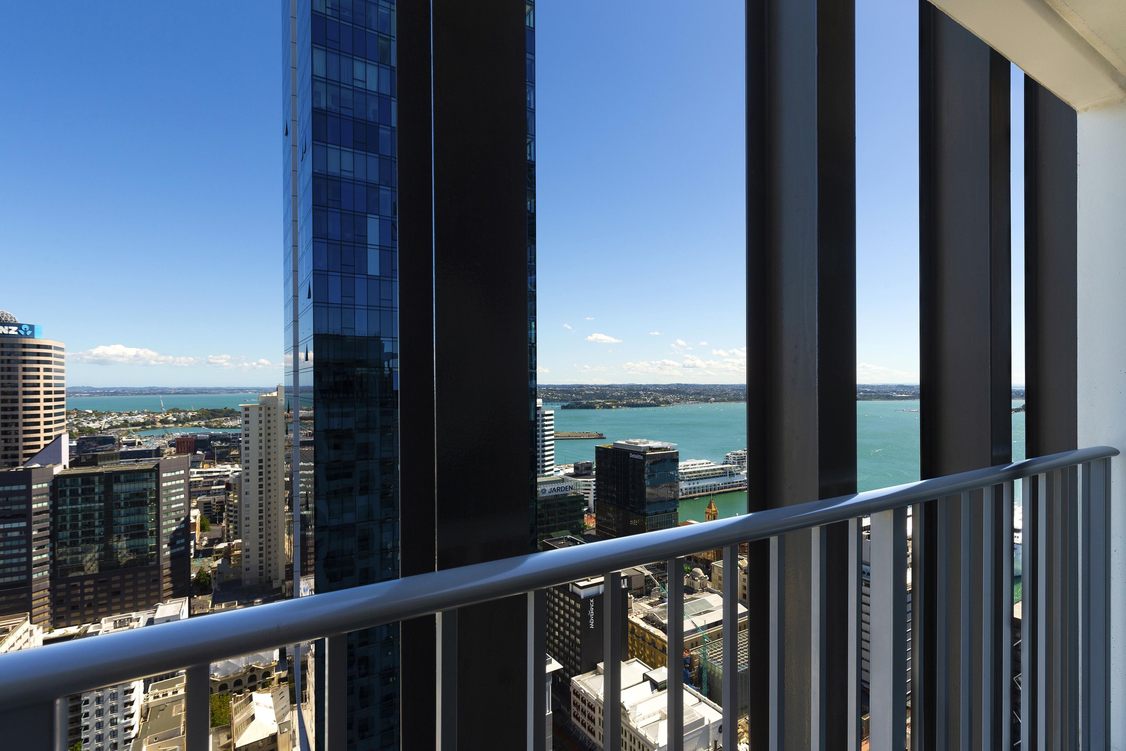 Un edificio alto con vistas a una masa de agua y otros edificios.