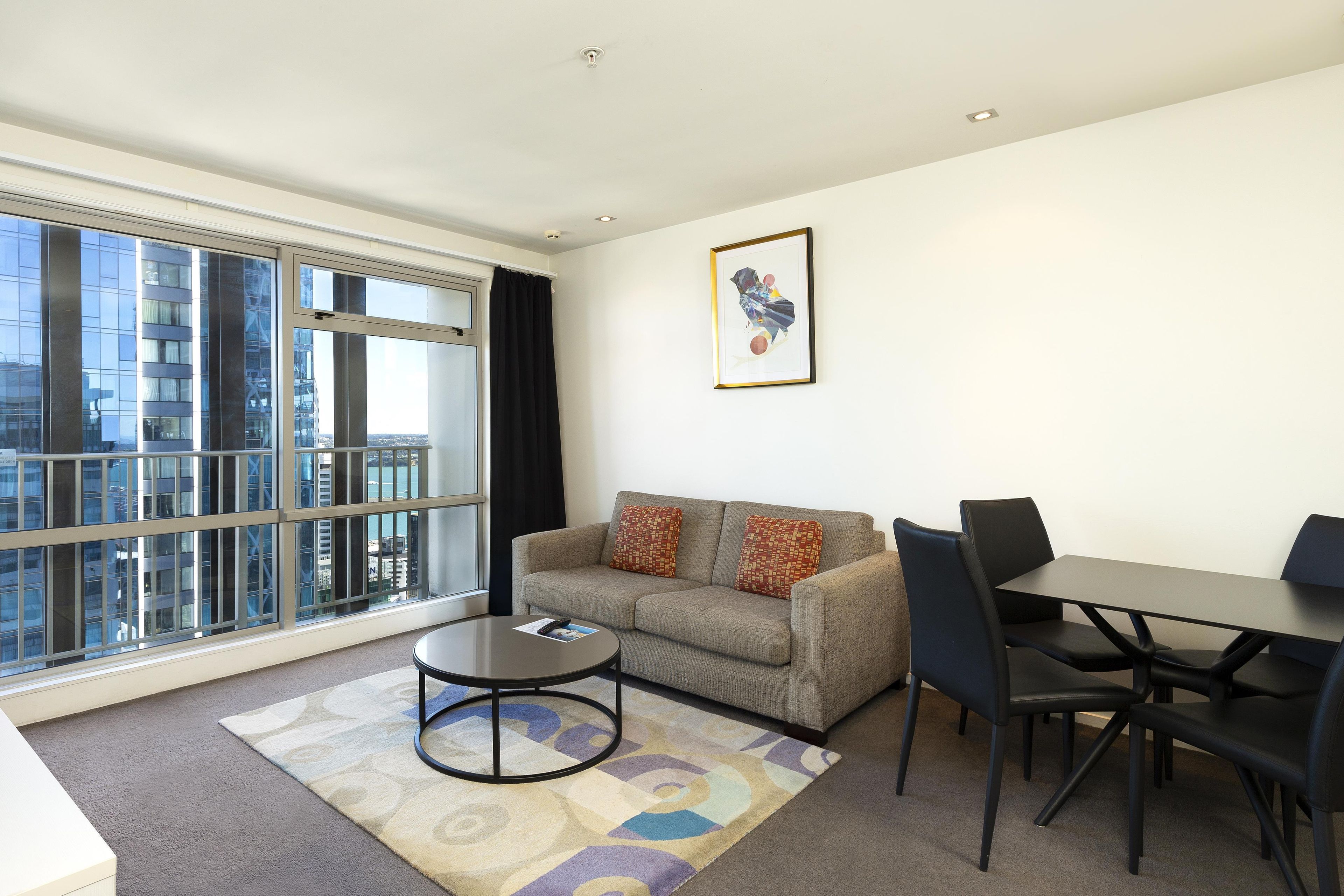 A modern living room with a sofa, coffee table, and dining area.