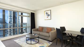A modern living room with a sofa, coffee table, and dining area.