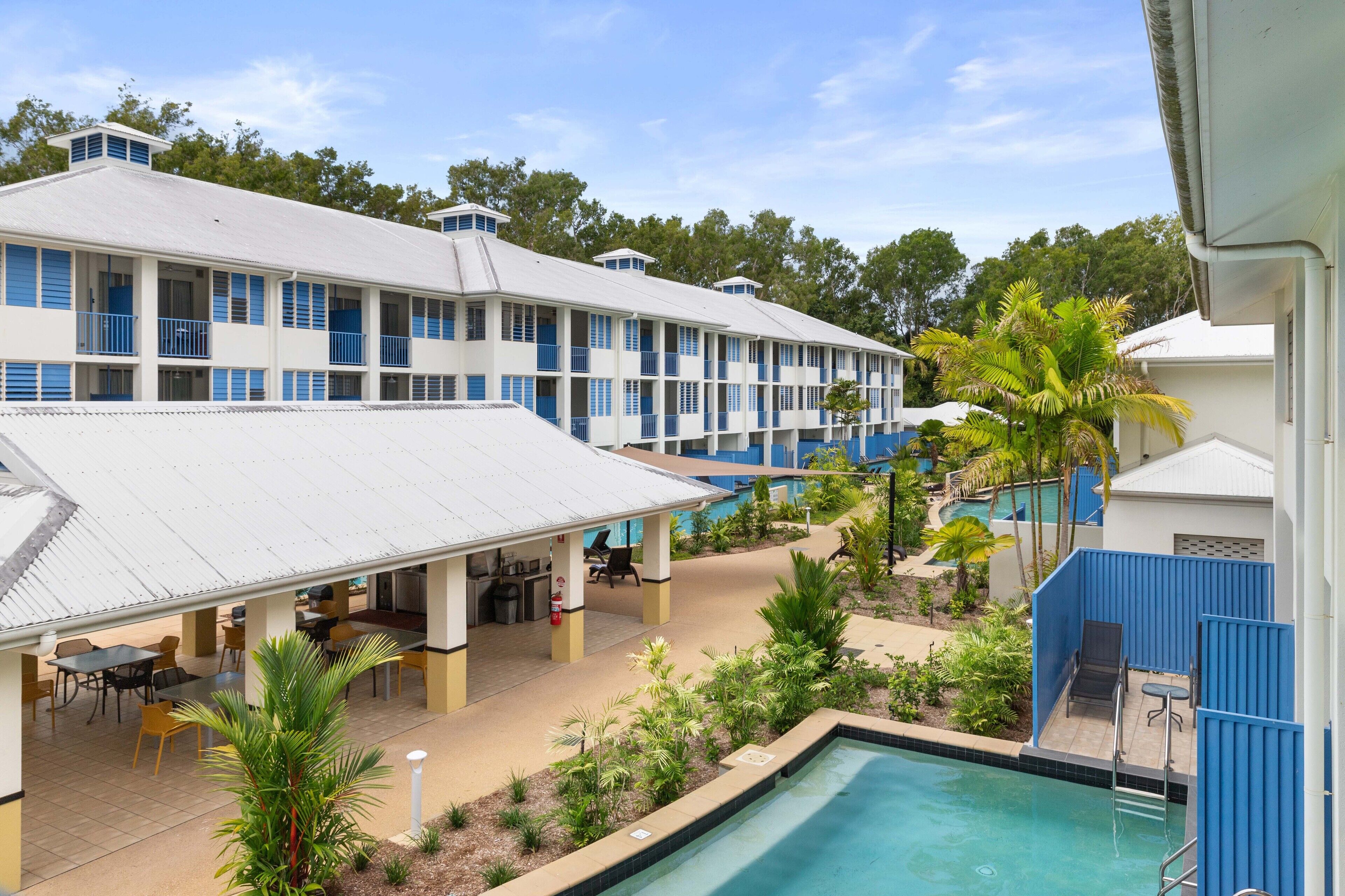 A hotel with multiple floors, outdoor pool, and dining area.
