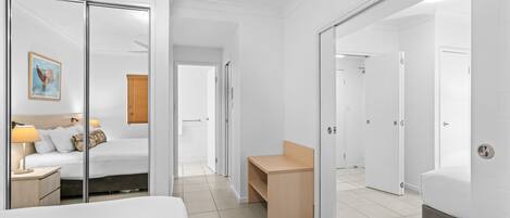 Une chambre d’hôtel avec un lit, une table de chevet, une lampe et un tableau encadré au mur.