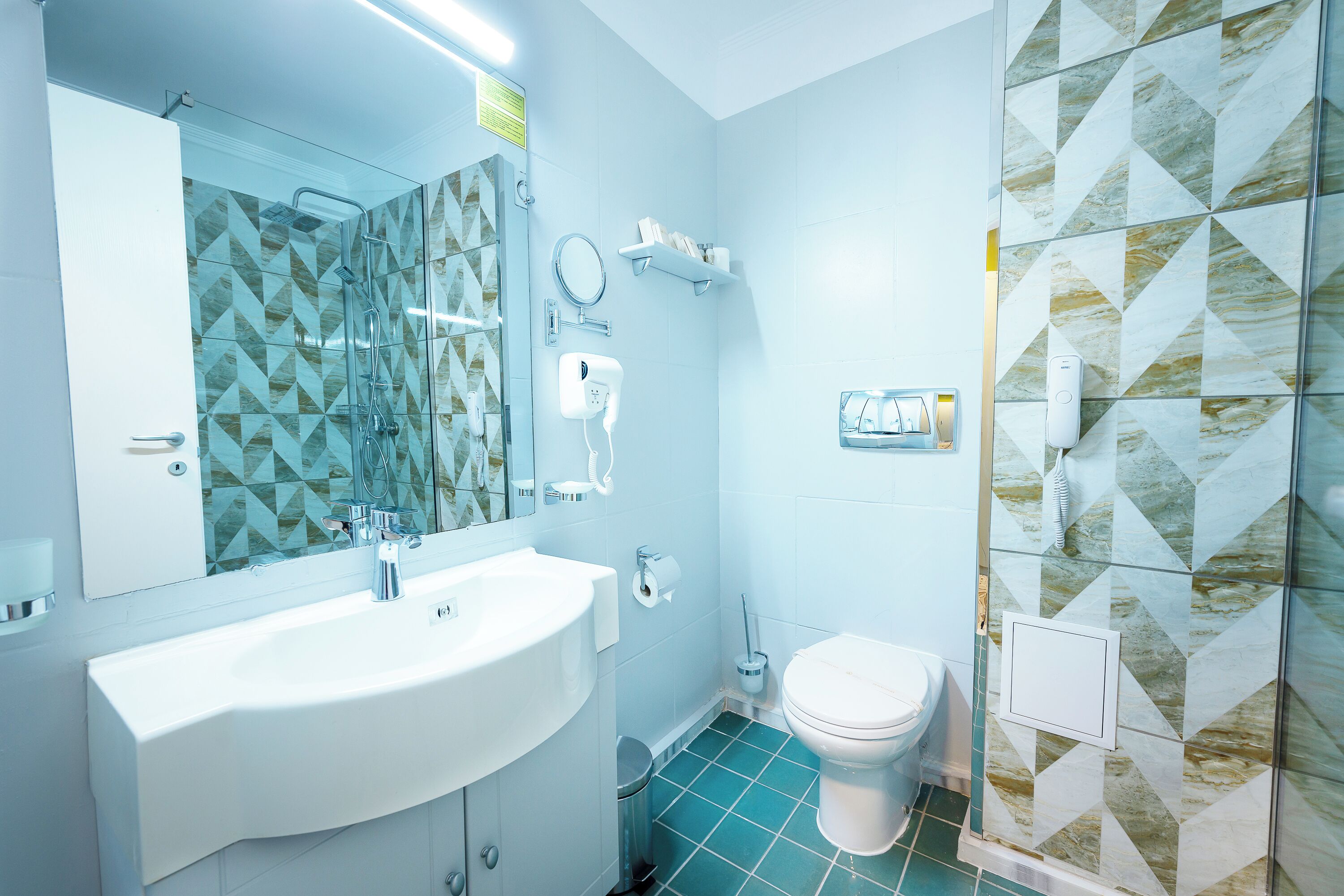 Un baño moderno con un lavamanos grande, inodoro y cabina de ducha de vidrio.