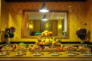 A buffet setup with various food items and a mirror above. - Phoenicia Grand Hotel (Bucharest)