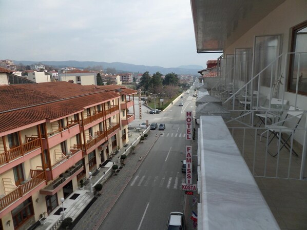 A hotel named "HOTEL FAMISI" with a view of a street and buildings in the background. - Hotel Kosta Famissi (Kalabaka)