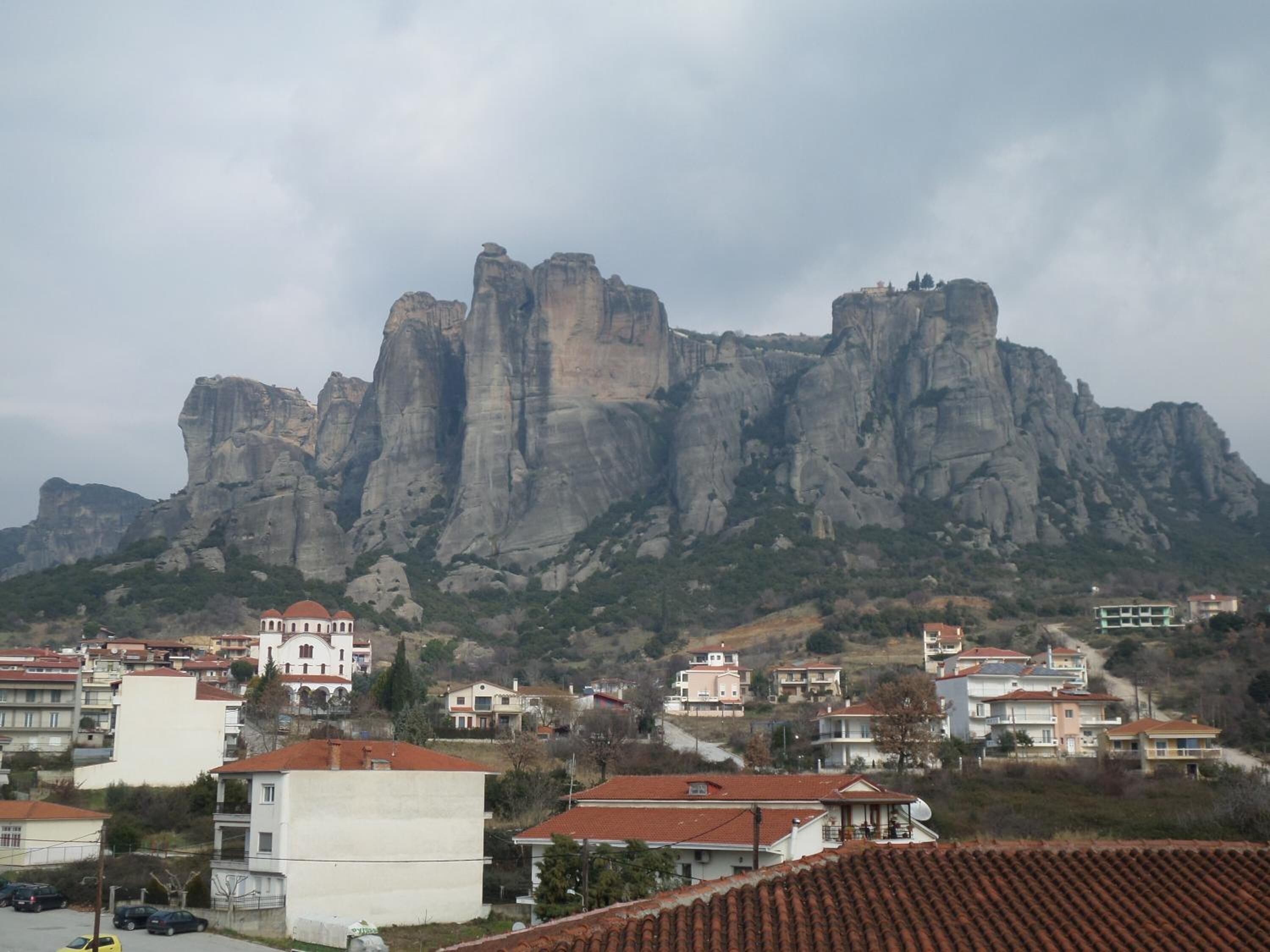 Eine Stadt mit Gebäuden und einem markanten Felsen im Hintergrund.