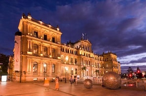Ein historisches Gebäude mit klassischer Architektur, einem zentralen Innenhof und einer großen, kugelförmigen Skulptur.