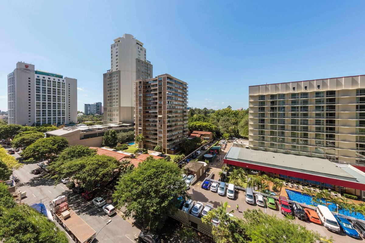 Un hôtel à plusieurs étages au design moderne, doté d’un espace piscine et d’un parking.