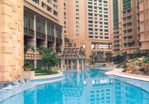 Une grande piscine intérieure entourée d’immeubles de grande hauteur dotés de balcons et d’un petit pavillon.