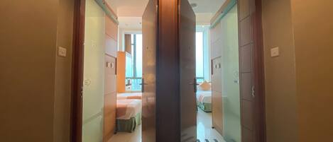 Una habitación de hotel con una cama, una ventana y una puerta que da a otra habitación.