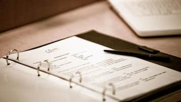 A planner with a pen on a wooden surface.