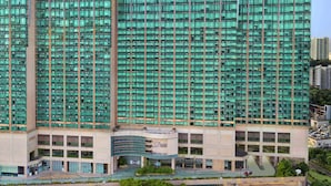 Un edificio de gran altura con un diseño arquitectónico moderno, que cuenta con varios balcones y una amplia fachada de vidrio.