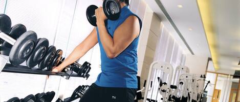 A gym with various exercise equipment, including dumbbells and weight machines.