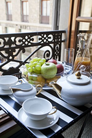 A breakfast table with a fruit bowl, plates, cups, a pitcher, and a glass of orange juice. - Porcellino Gallery (Florence)