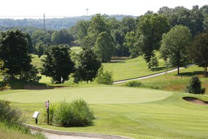 A golf course with a stop sign, a signpost, and a water tower in the background. - Branson Condo Resorts by Andy Williams Theatre (Branson)