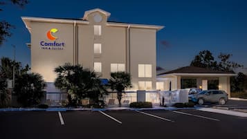 Ein Comfort Inn & Suites Hotel mit Parkplatz und überdachter Eingang.