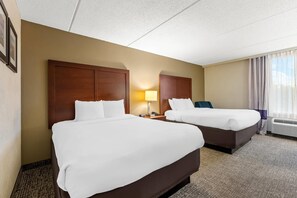 A hotel room with two beds, a nightstand, a lamp, and a window with curtains. - Comfort Inn & Suites (Panama City)
