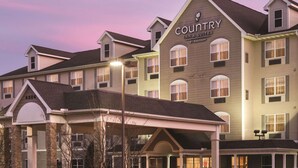 A multi-story hotel with a Country Inn & Suites sign, featuring a traditional architectural style with a covered entrance and multiple windows. - Country Inn & Suites by Radisson, Bentonville South - Rogers, AR (Rogers)