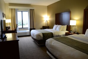 A hotel room with two beds, a desk with a lamp, a chair, a nightstand with a phone, and a window with curtains. - Comfort Inn & Suites Cave City (Cave City)