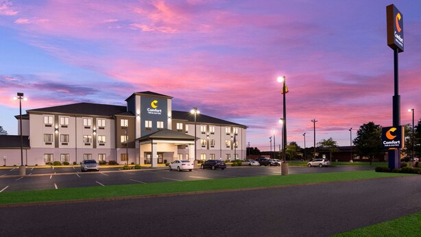 A Comfort Inn & Suites hotel with a parking lot and a grassy area in front.