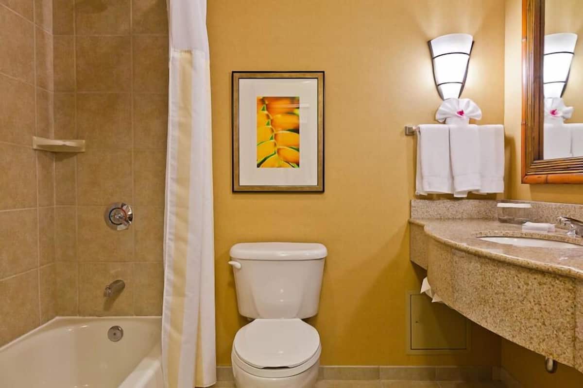 A bathroom with a bathtub, toilet, and sink.