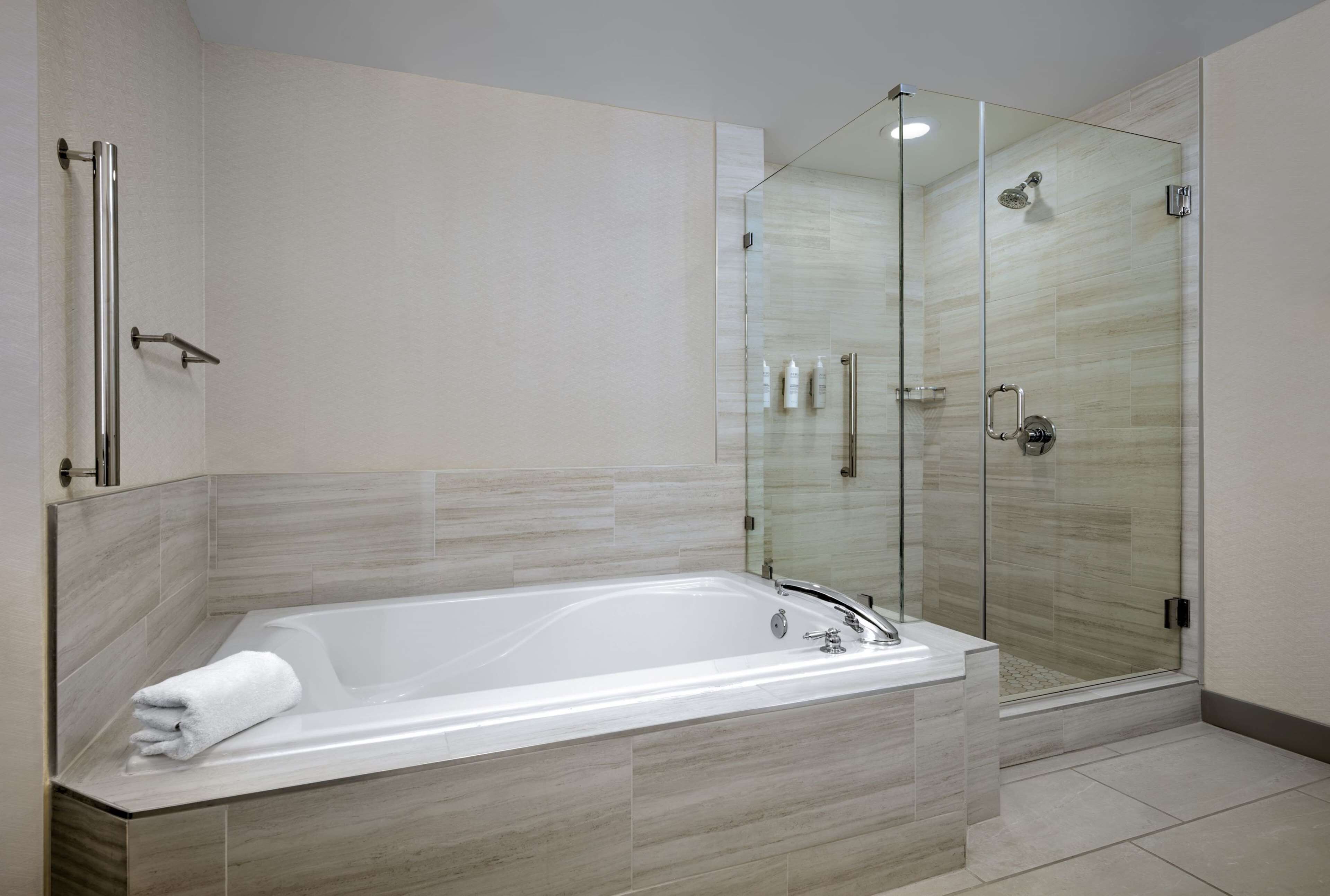 A modern bathroom with a freestanding bathtub, a glass-enclosed shower, and a walk-in shower.