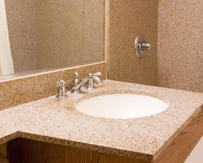 A bathroom with a granite countertop, a white sink, and a mirror. - Econo Lodge Portland Downtown (Portland)