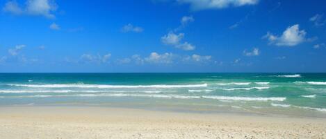 On the beach, white sand, sun-loungers, beach umbrellas