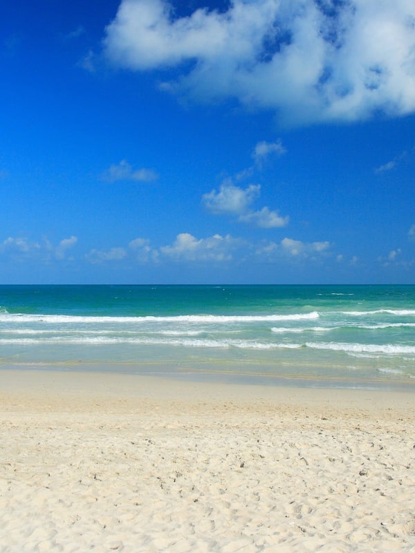 On the beach, white sand, sun loungers, beach umbrellas
