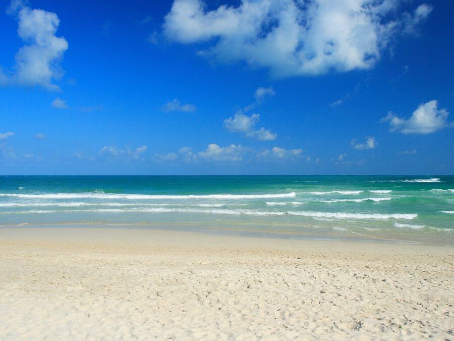 On the beach, white sand, sun loungers, beach umbrellas