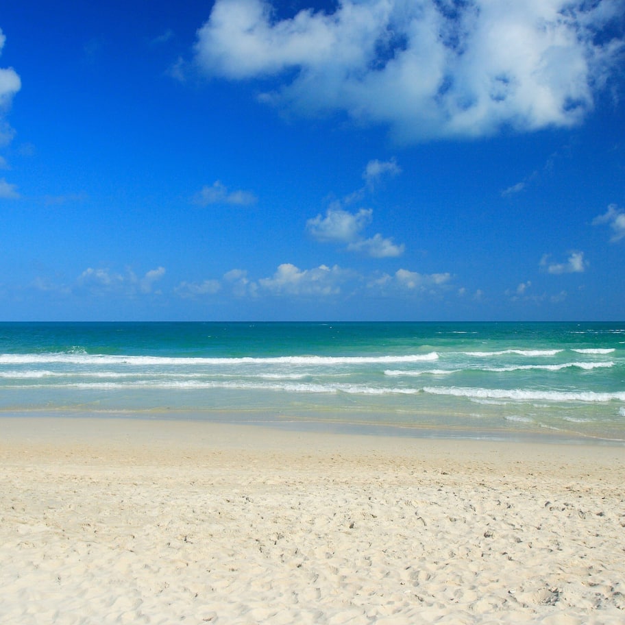 On the beach, white sand, sun loungers, beach umbrellas