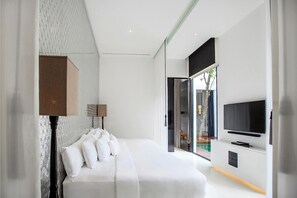 A modern bedroom with a large bed, a flat-screen TV mounted on the wall, and a view of the outdoors through a glass door.