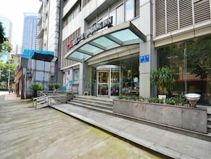 A modern building with a glass entrance, a staircase leading to the entrance, and a blue sign indicating the location. - Jinjiang Inn ChengDu Wenshufang (Chengdu)
