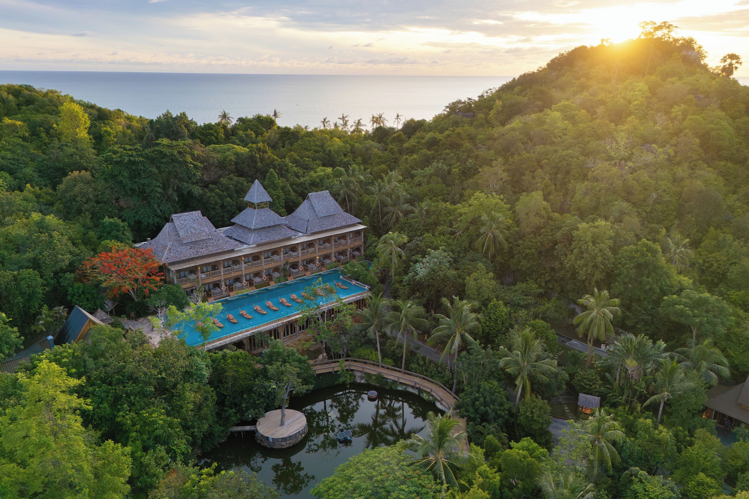 Ein Resort mit Pool, einer Brücke und Blick aufs Meer.
