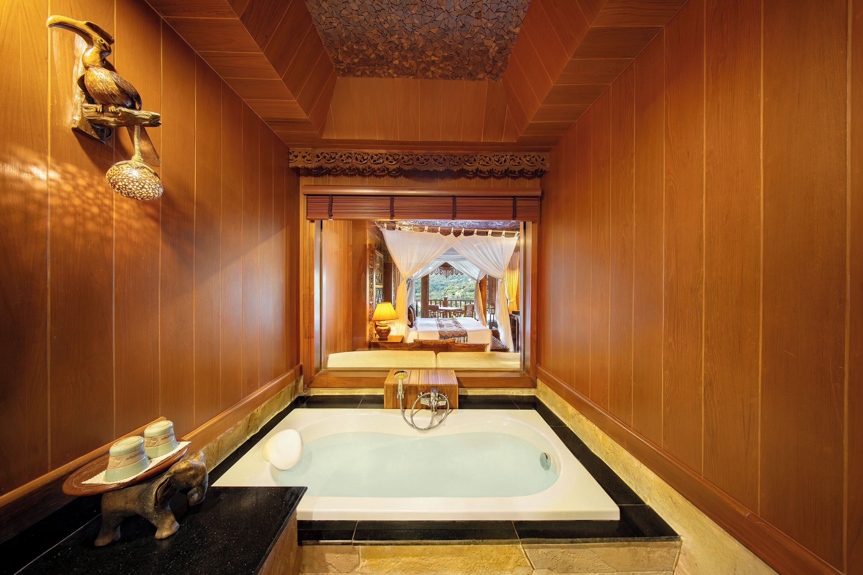 A bathroom with a bathtub, a shower, and a wooden wall.