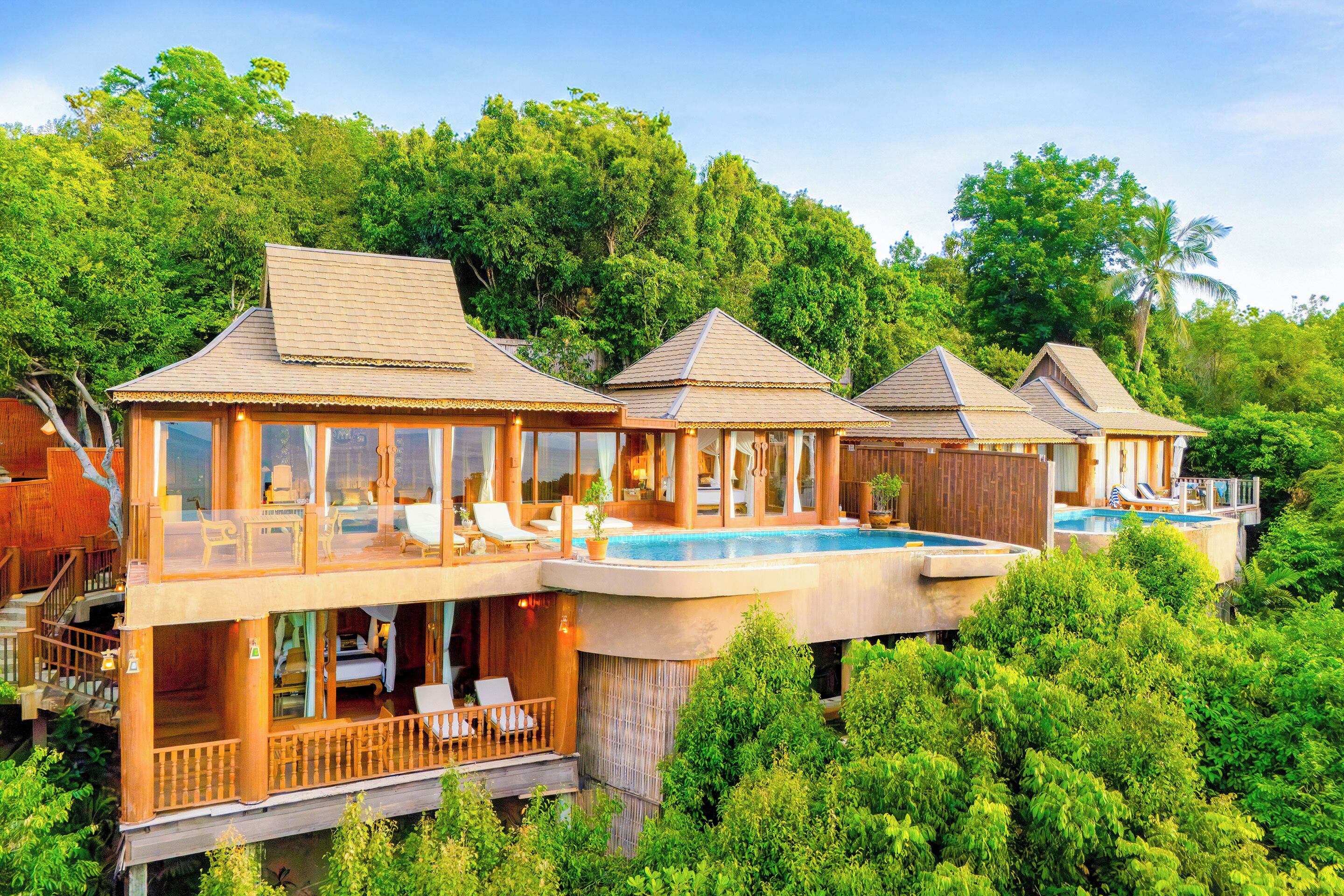A resort with multiple overwater bungalows featuring balconies, outdoor seating, and a central pool.