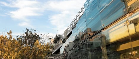 Un edificio moderno con fachada de vidrio y una escalera que conduce a un nivel superior.